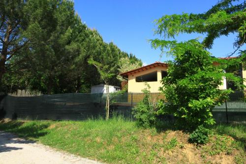 a house with a fence in front of a yard at Camping Village la Chiocciola in Capannole