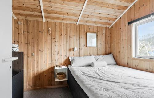 a bedroom with a bed in a wooden wall at Stunning Home In Sjlund With Kitchen in Sjølund