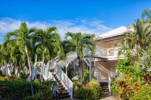 a house with palm trees in front of it at Galley Bay Resort & Spa in Saint Johnʼs