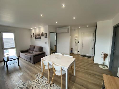 a living room with a table and a couch at Appartement climatisé in Charmes