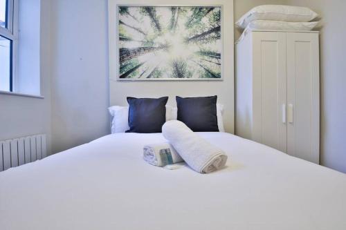 a bedroom with a white bed with blue pillows at StayRight 1-Bed City Nest in Cardiff in Cardiff