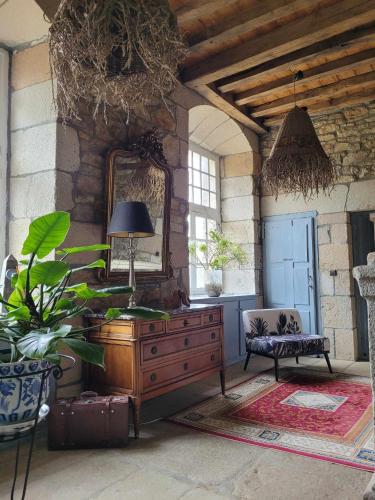 a room with a dresser and a mirror and a chair at Manoir De Keringant in Saint-Quay-Perros