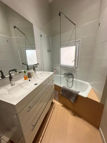 a bathroom with two sinks and a tub and a mirror at L'Appart 6 in Aix-en-Provence