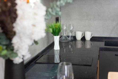 um balcão preto com copos de vinho e flores em Apart Hotel New Line em Tbilisi