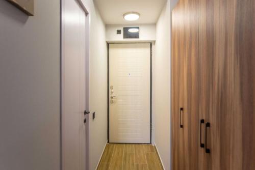 um corredor com uma porta branca e um piso de madeira em Apart Hotel New Line em Tbilisi