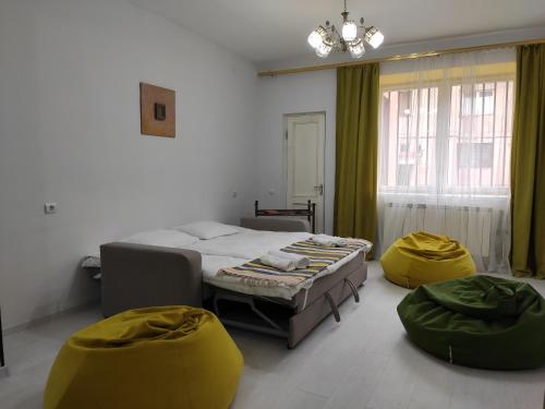 a bedroom with a bed and two yellow chairs at Ners Guest House in Gyumri