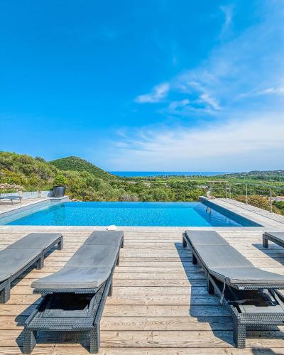 - une piscine avec bancs sur une terrasse en bois dans l'établissement Villa Lavu Santu piscine privée vue mer/montagnes, à Zonza