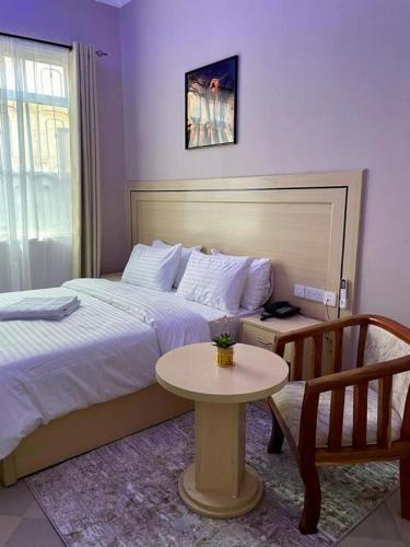 a hotel room with a bed and a table at ROSA HOTEL AND APARTMENT - ILAZO in Dodoma