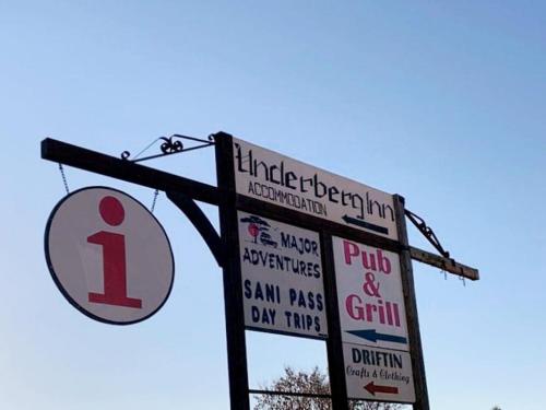 a street sign with signs on a pole at UNDERBERG INN in Underberg