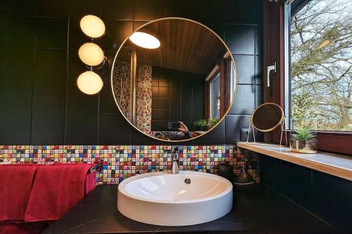 a bathroom with a large round sink and a mirror at Wohnen in der Galerie in Worpswede