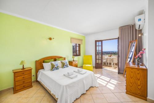 ein Schlafzimmer mit einem großen Bett und einem Balkon in der Unterkunft Villa Casa Coelho by Villa Plus in Terras Novas