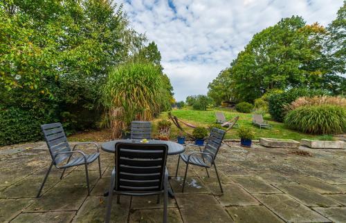 a patio with a table and chairs in a garden at Apartmány Modrá Vrata in Stříbřec