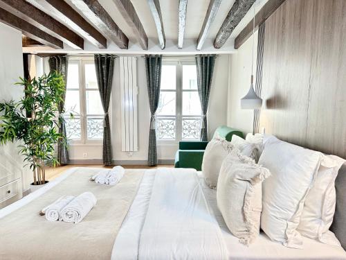 um quarto com uma grande cama branca com toalhas em 2066 - Duplex in Saint-Germain Olympic Games 2024 em Paris