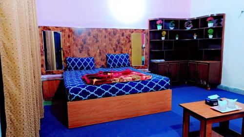 sypialnia z łóżkiem z niebieską kołdrą w obiekcie The Royal Family Couples Guest House w mieście Lahaur