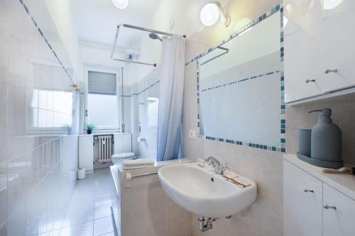 Baño blanco con lavabo y espejo en Navigli House Milano with fast WI-FI, en Milán