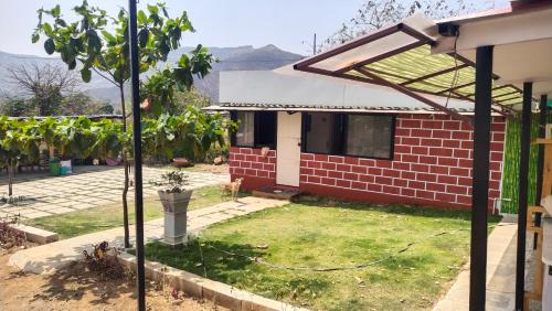 a red brick house with a lawn in front of it at The Wai Hills MTDC Approved in Wai
