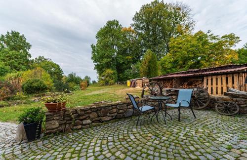 a patio with a table and chairs and a stone wall at Apartmány Modrá Vrata in Stříbřec