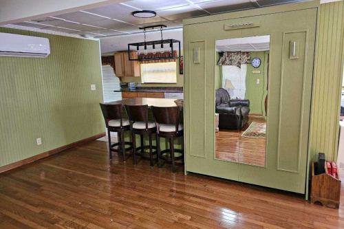 a living room with a kitchen and a bar with chairs at Hidden Creek Cabin in Franklin