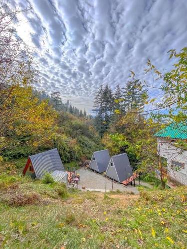 a group of four tents sitting in a field at The Heavens Place in Nagar