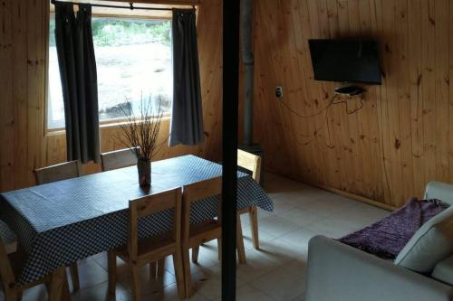 a dining room with a table and a window at La Torre del Rio in Lago Meliquina