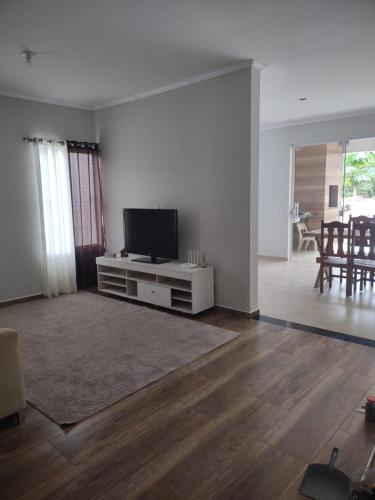 una sala de estar con TV de pantalla plana en un armario blanco en Aconchego Cuesta de Botucatu Ninho verde 2, en Pardinho