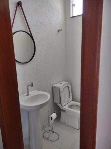a bathroom with a sink and a toilet and a mirror at Aconchego Cuesta de Botucatu Ninho verde 2 in Pardinho