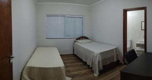 Cette petite chambre comprend un lit et une fenêtre. dans l'établissement Aconchego Cuesta de Botucatu Ninho verde 2, à Pardinho