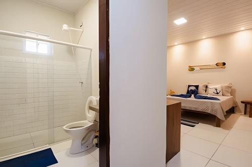 baño con cama y aseo en Flats Japaratinga - a 200m da praia com varanda en Japaratinga