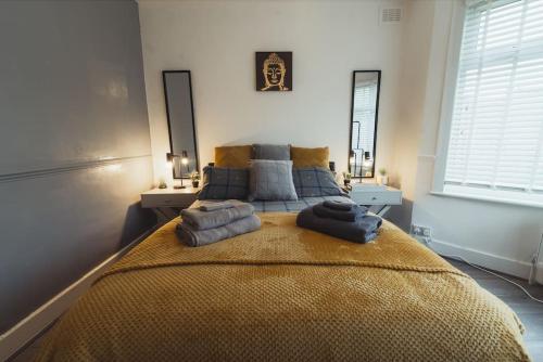 a bedroom with a large bed with towels on it at 1 bed - Wifi - Pet Friendly - Harrow in Harrow
