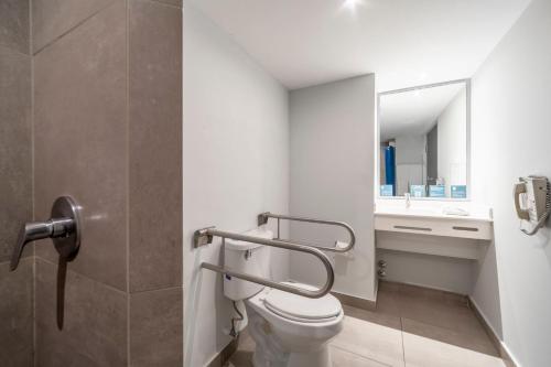 uma casa de banho com um WC e um lavatório em City Express Junior by Marriott Ciudad del Carmen em Ciudad del Carmen