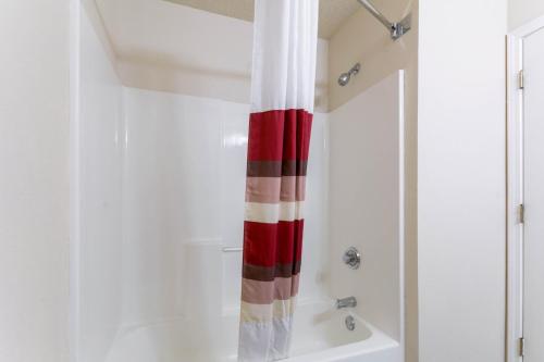a bathroom with a red and white shower curtain at Red Roof Inn Carrollton in Carrollton