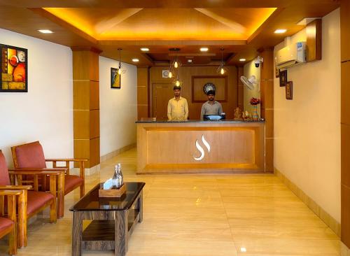 two men standing at the bar in a hotel lobby at Shree Residency in Erode