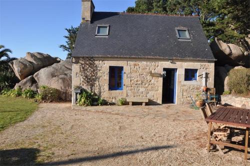 een stenen huis met een bankje ervoor bij Maison bretonne 50m plage avec jardin et WIFI à TREGASTEL - Réf 413 in Trégastel