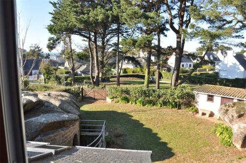 een uitzicht op een tuin vanuit een huis bij Maison bretonne 50m plage avec jardin et WIFI à TREGASTEL - Réf 413 in Trégastel