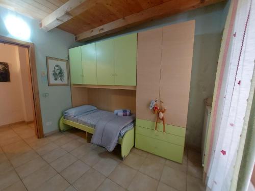 ein kleines Schlafzimmer mit einem Bett und grünen Schränken in der Unterkunft AgneseApartment171 in Ancona