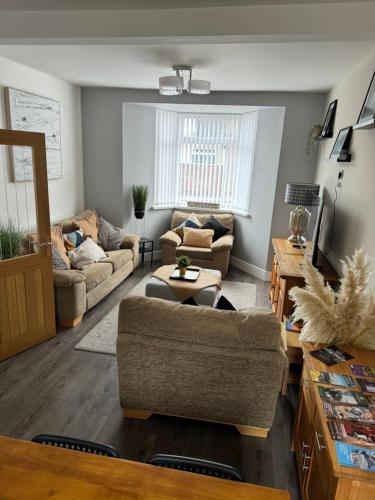 a living room with two couches and a table at Modern, spacious and Central Location in Aberdare