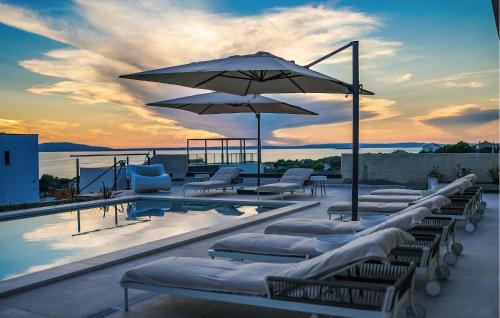 ein Swimmingpool mit Liegestühlen und Sonnenschirm in der Unterkunft Lovely Home In Jakisnica With Sauna in Jakišnica