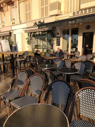 an empty restaurant with tables and chairs in front of a building at Naomi cannes in Cannes