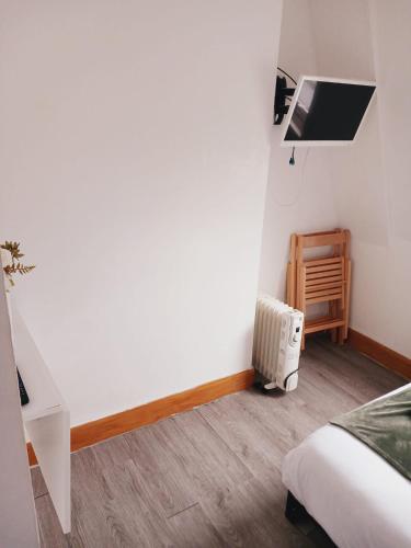 a bedroom with a bed and a desk and a radiator at F407-4th Flr Studio for 2 Near Hyde Park in London