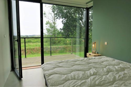 Schlafzimmer mit einem Bett und einem großen Glasfenster in der Unterkunft Maison de plain-pied avec WIFI, jardin, terrasse à PLEUMEUR - BODOU REF-457 in Pleumeur-Bodou
