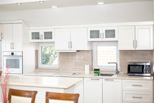 a white kitchen with white cabinets and a sink at ForS Resort & Spa in Belgrade