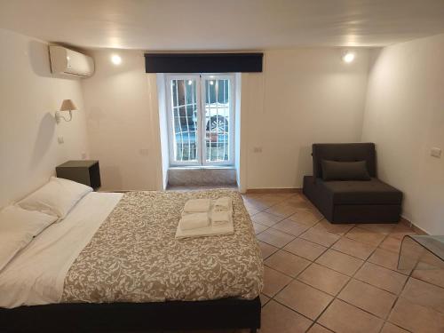 a bedroom with a bed and a chair and a window at Amedeo Square in Naples