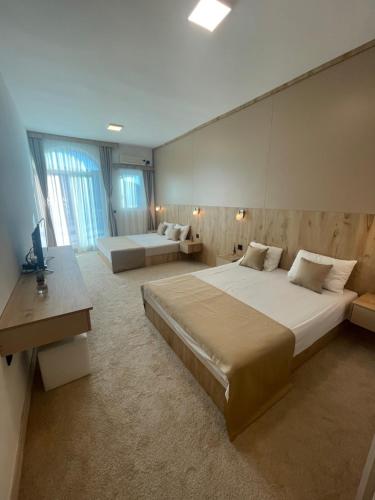 um quarto grande com 2 camas e uma televisão em El Mar Hotel em Bar