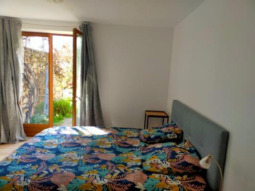 Vérin的住宿－La Verdine，一间卧室配有一张带五颜六色棉被的床