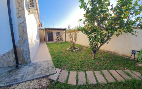 a yard with an orange tree next to a building at La Terrazza - 150m dal mare - [Ampia Terrazza Privata+Area Relax] in Arenella