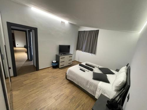 a bedroom with a bed and a flat screen tv at Industrial House 3 in Corsico