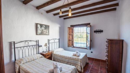 1 dormitorio con 2 camas y ventana en Casa Rosario Almachar by Ruralidays, en Almáchar