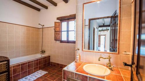 y baño con lavabo, bañera y espejo. en Casa Rosario Almachar by Ruralidays, en Almáchar