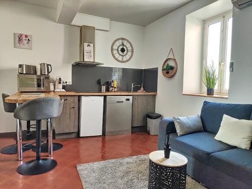 un salon avec un canapé bleu et une cuisine dans l'établissement Le Barès, à Carcassonne