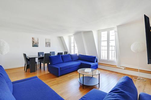 un salon avec un canapé bleu et une table dans l'établissement Pick A Flat's Apartment in Champs-Elysées - Rue Ponthieu, à Paris